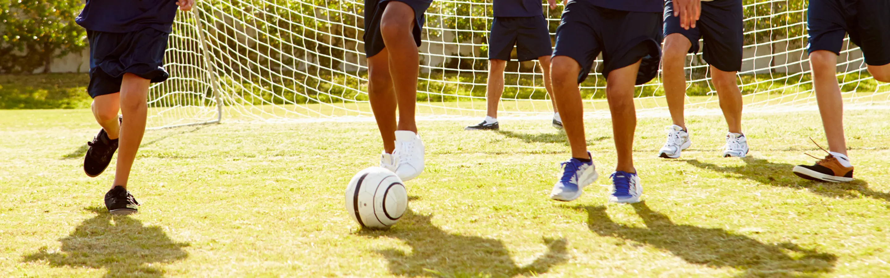 Children playing soccer on a grassy field.