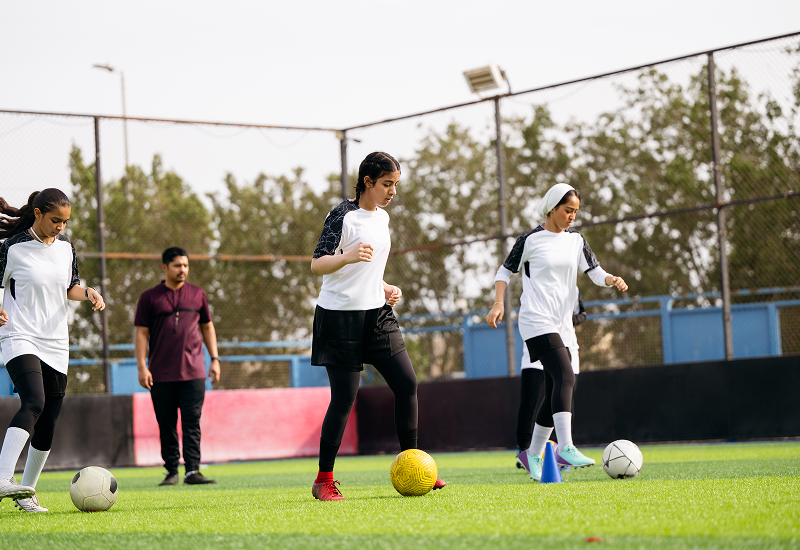 Several young individuals playing soccer on a field, demonstrating skill and collaboration in a lively match.